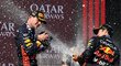 Vítěz Velké ceny Maďarska Max Verstappen schytává spršku šampaňského od parťáka Sergia Pereze
