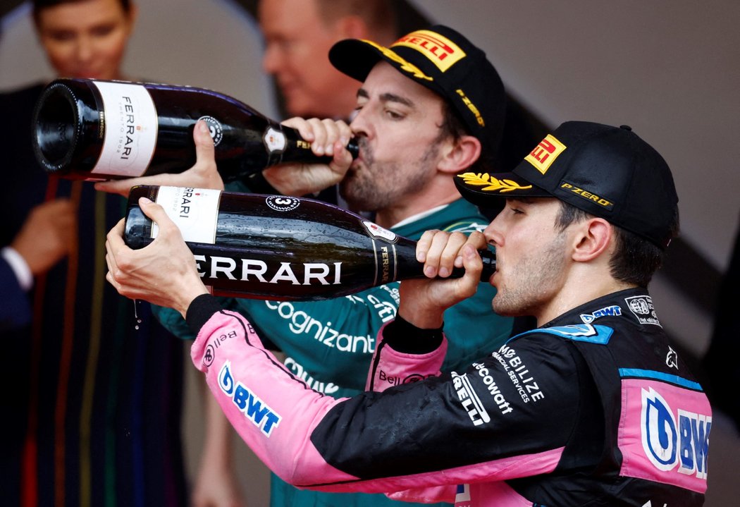 Druhý Fernando Alonso (vlevo) s třetím Estebanem Oconem popíjejí šampaňské
