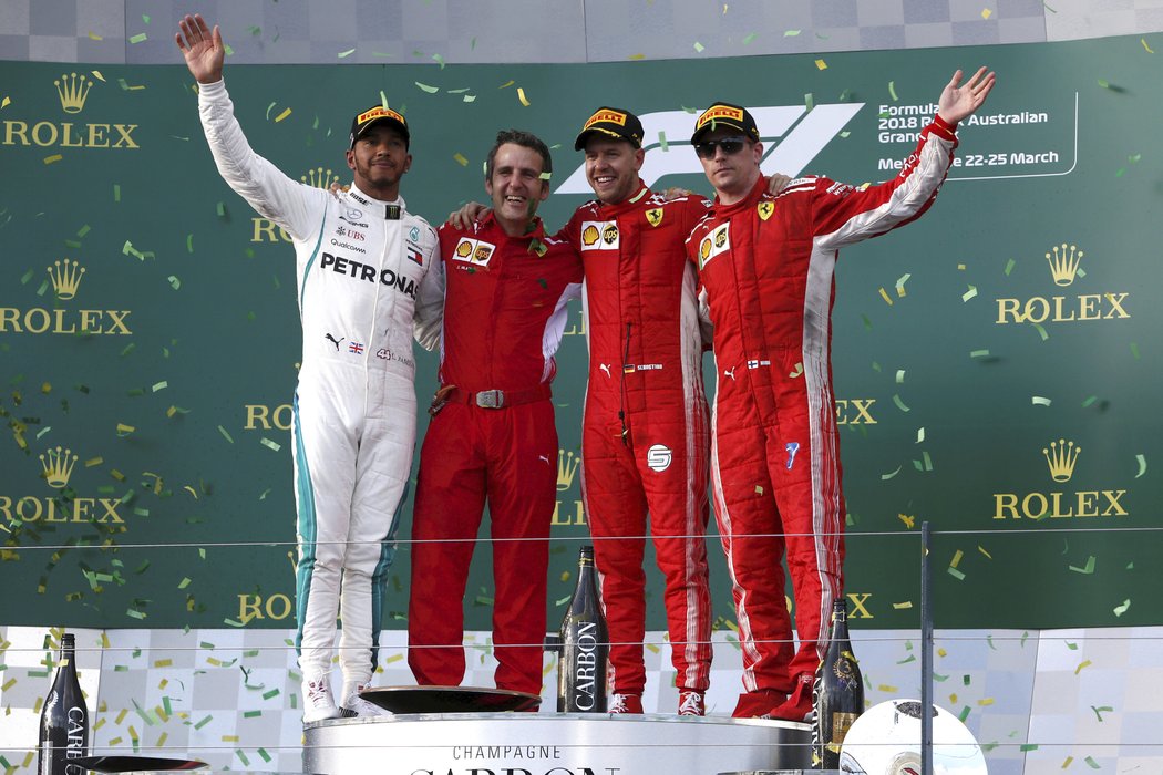 Lewis Hamilton se na pódiu ocitl v obležení červených barev