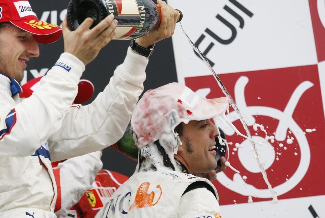 Polský pilot Robert Kubica polévá vítězným šampaňským Fernanda Alonsa.