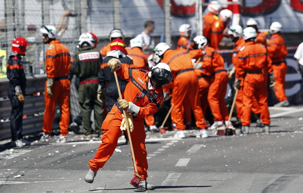 Pracovníci na trati odklízejí pozůstatky po nehodě Pastora Maldonada