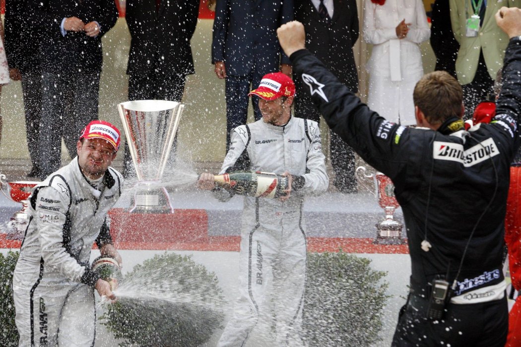 Šampusová bitva pilotů Brawn GP Jensona Buttona a Rubense Barrichella (vlevo).