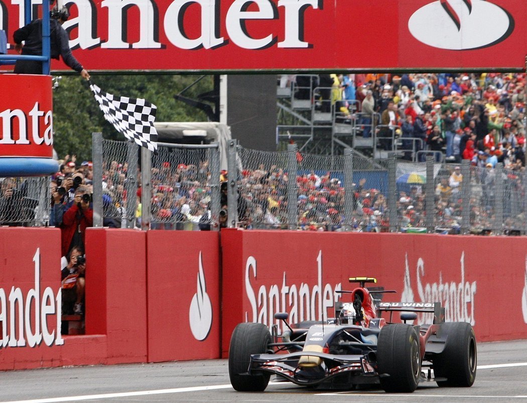 Sebastian Vettel projíždí vítězně cílem.