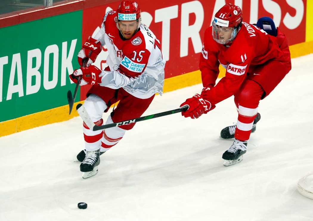 Matias Lassen z Dánska (vlevo) se snaží uniknout ruskému hokejistovi Dmitriji Voronkovovi