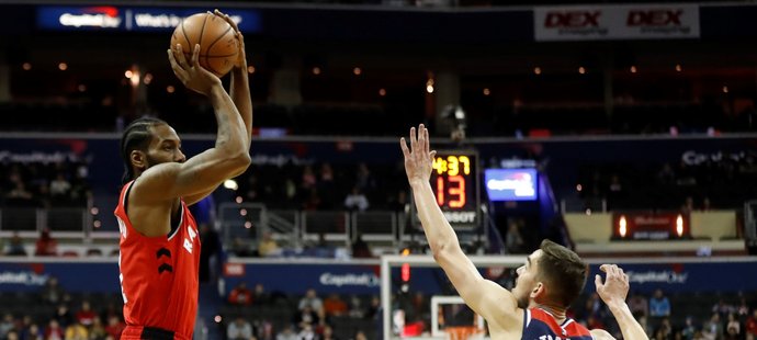 Český basketbalista Tomáš Satoranský se snaží blokovat střelu v zápase NBA mezi Washingtonem a Torontem