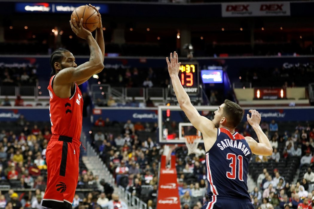 Český basketbalista Tomáš Satoranský se snaží blokovat střelu v zápase NBA mezi Washingtonem a Torontem