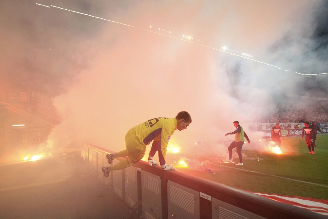 Gólman Herthy Berlín Thomas Kraft uniká před řáděním fanoušků v utkání na hřišti Fortuny Düsseldorf