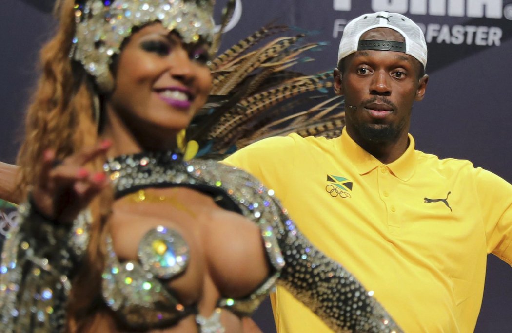 Usain Bolt sleduje tanečnice samby při své velkolepé tiskové konferenci v olympijském Riu