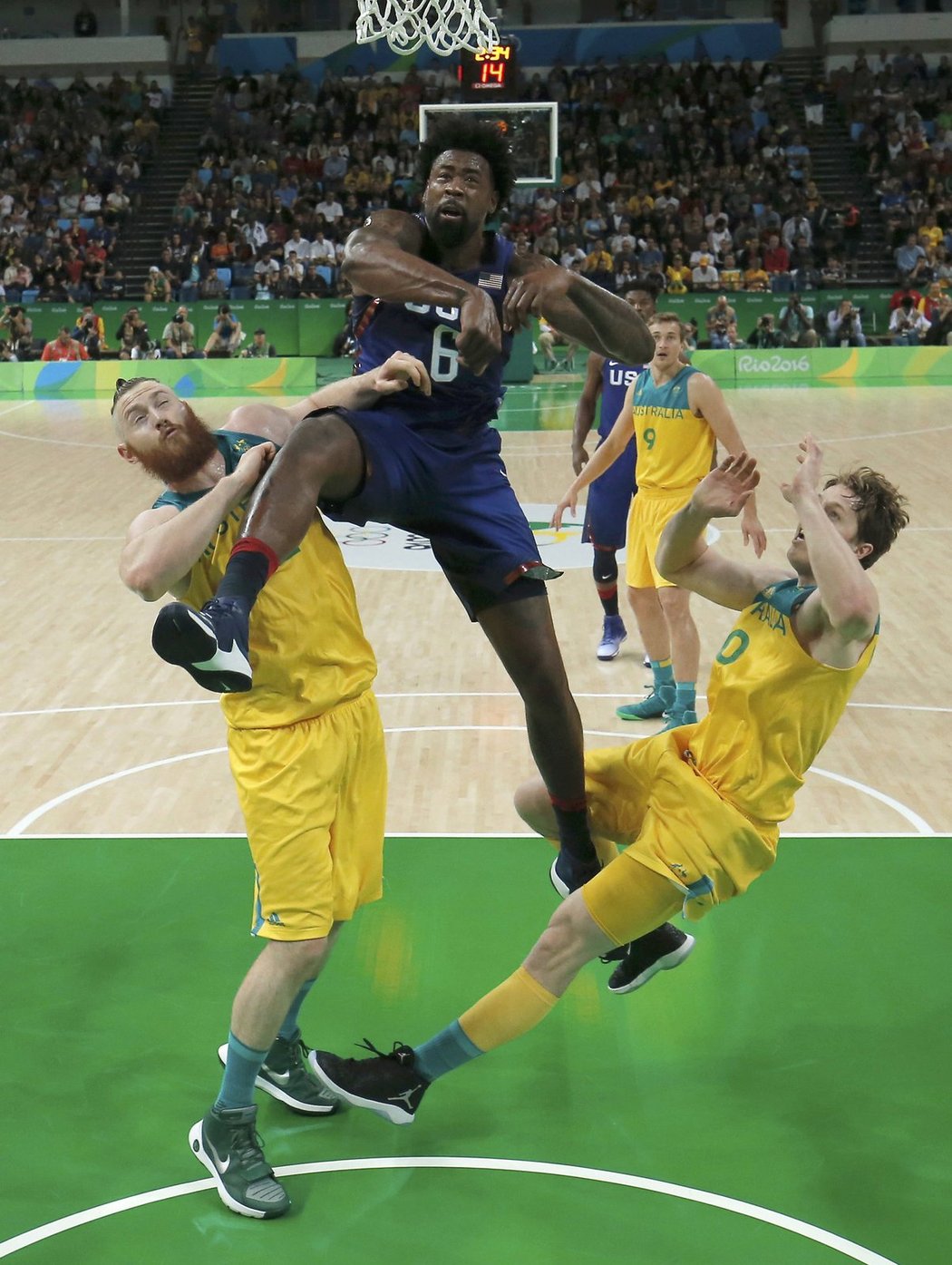 Američan Deandre Jordan jde hodně tvrdě do koše přes australské obránce