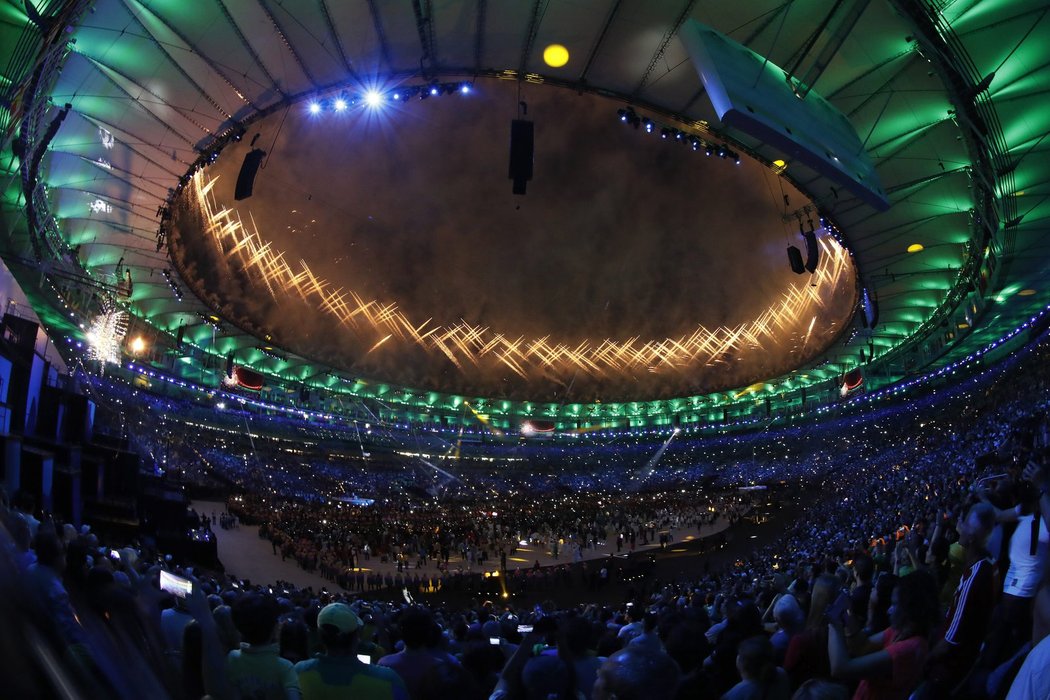 Scéna ze závěru zahajovacího ceremoniálu LOH v Riu. Vlevo hoří olympijská oheň a vystřeluje slavnostní ohňostroj.