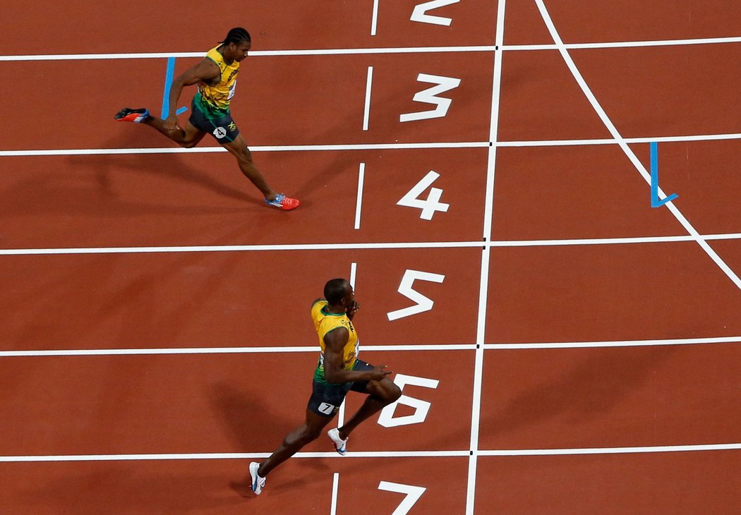 Usain Bolt (níže) protíná pomyslnou pásku dvoustouvky před krajanem Blakem opět ne v plném nasazení
