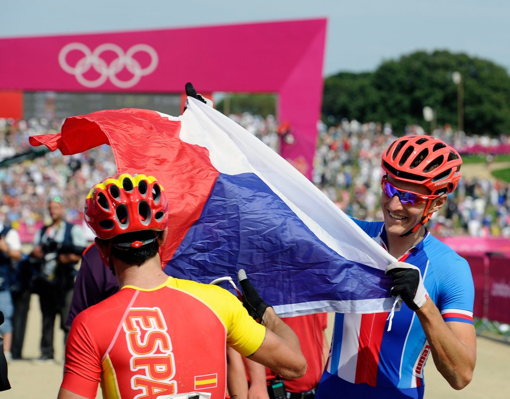 Jaroslav Kulhavý se raduje s českou vlajkou mezi ostatními závodníky