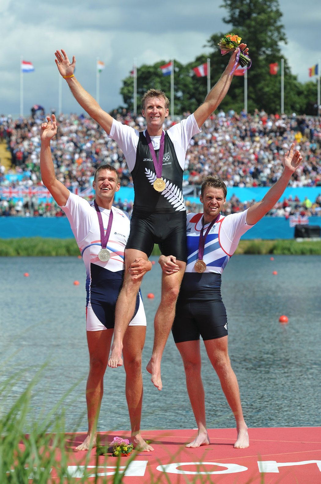Stříbrný Ondřej Synek (vlevo) a bronzový Alan Cambell zvedají na ramena olympijského vítěze Mahe Drysdala
