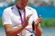 Ondřej Synek sleduje, jak se mu na prsou houpe stříbrná olympijská medaile