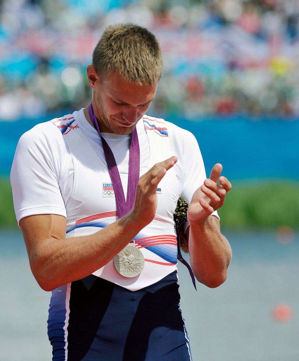 Ondřej Synek sleduje, jak se mu na prsou houpe stříbrná olympijská medaile