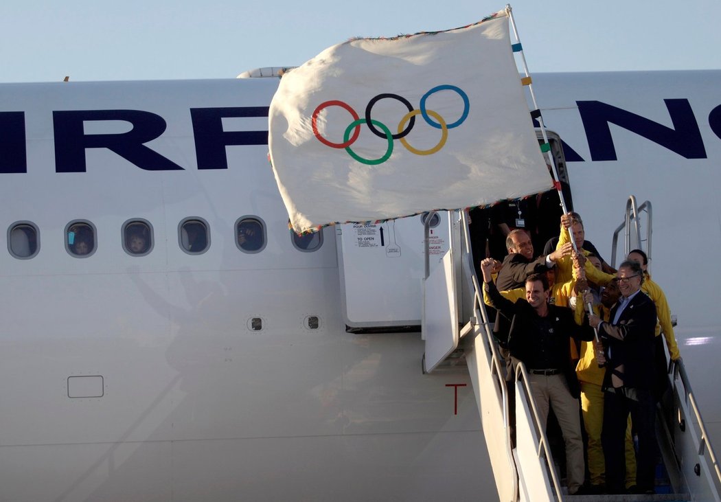 Starosta Ria de Janeira Eduardo Paes (vlevo) a šéf olympijského výboru Carlos Arthur Nuzman spolu s brazilskými sportovci přivážejí olympijskou vlajku do Ria de Janeira