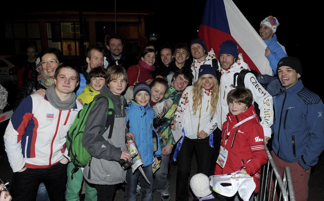 Gabriela Soukalová, Jaroslav Soukup a Ondřej Moravec se fotí s hloučkem fanoušků, který je v pondělí pozdě večer vítal po příletu z olympiády