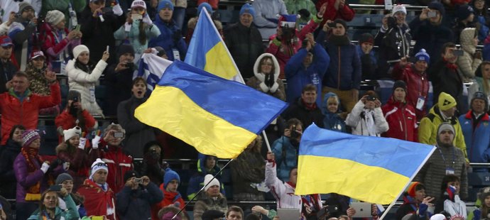 Ukrajinští fanoušci mávají vlajkami, zatímco Olena Pidrušná míří za zlatou medailí