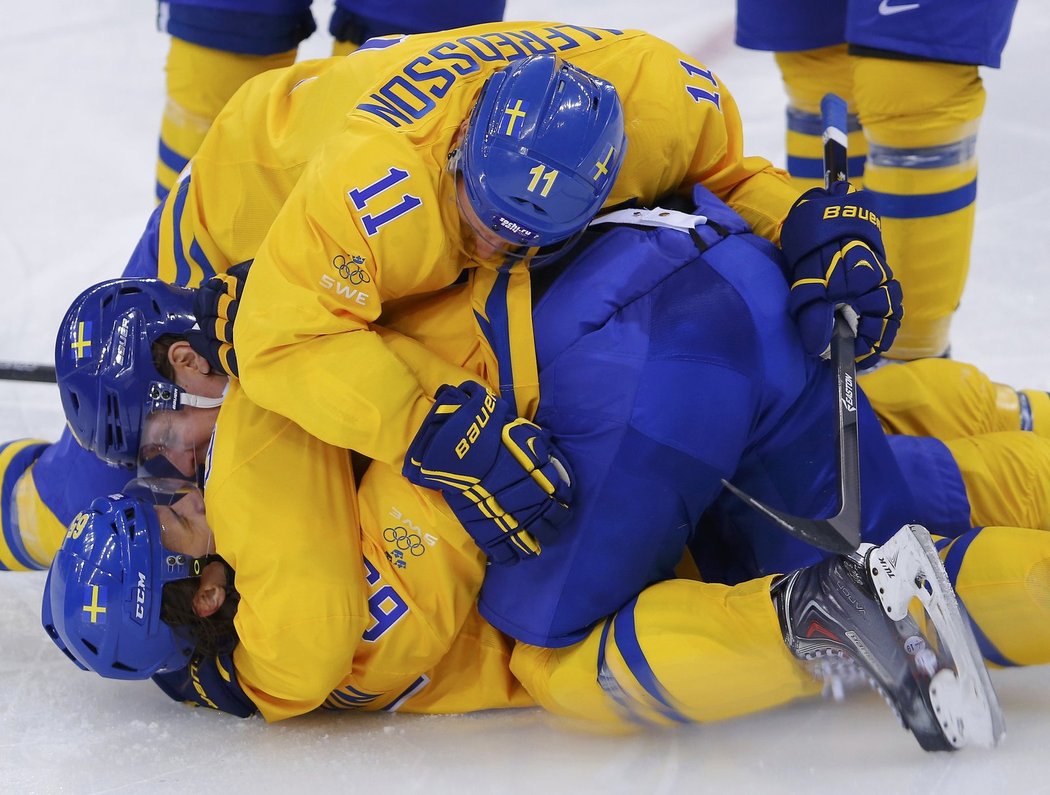 Trochu fotbalová oslava švédských hokejistů po gólu Erika Karlssona (dole) do sítě Lotyšů