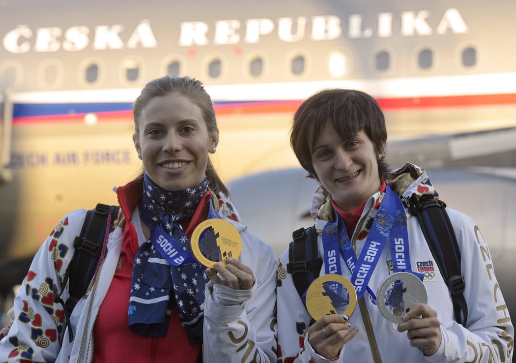 Eva Samková (vlevo) a Martina Sáblíková se chlubí svými medailemi po příletu do Prahy