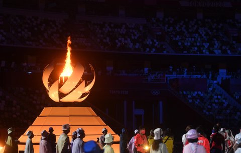Sportovci na slavnostním zakončení sledují olympijský oheň