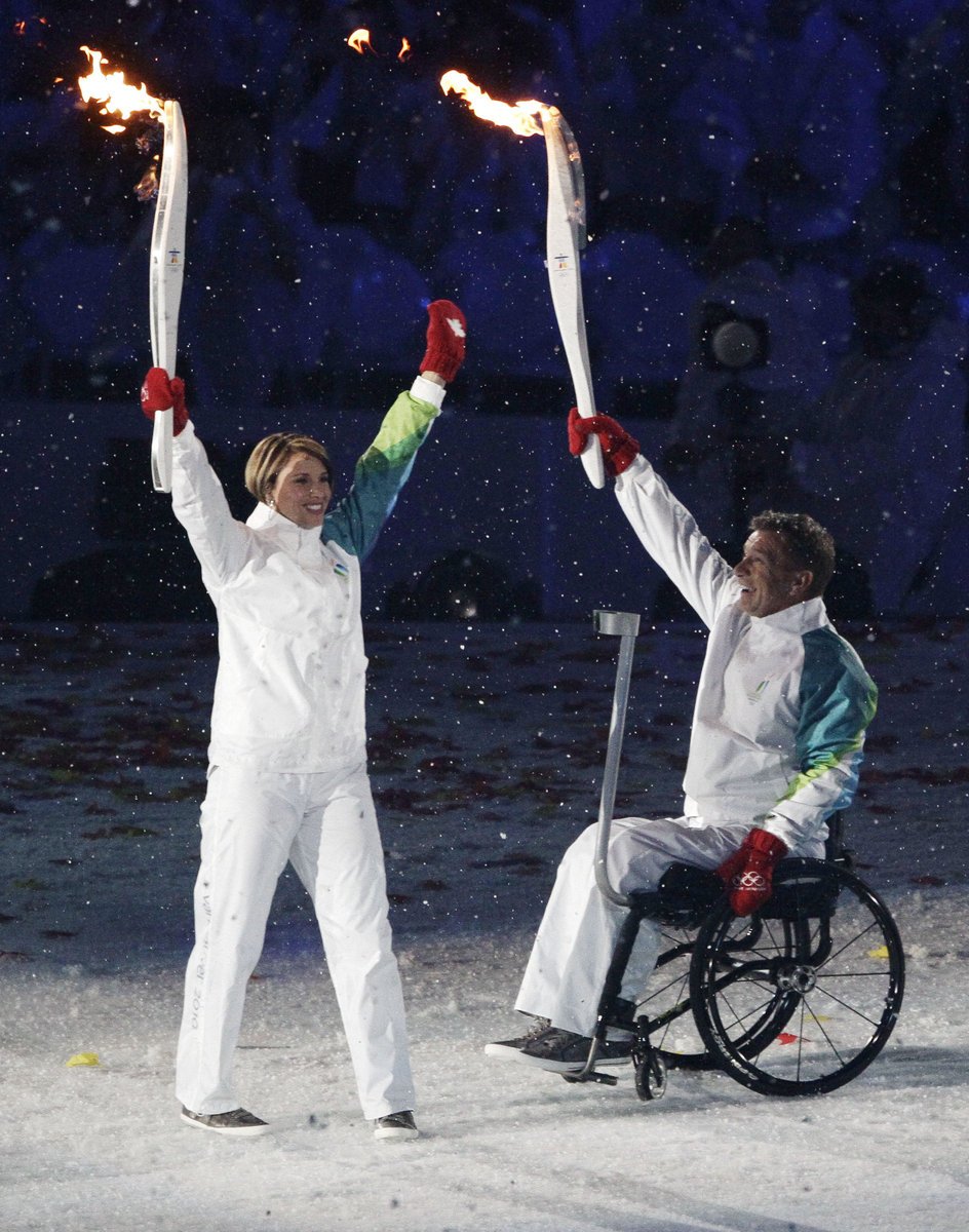 Rick Hansen (vpravo) předává olympijskou štafetu Catrioně LeMay Doan