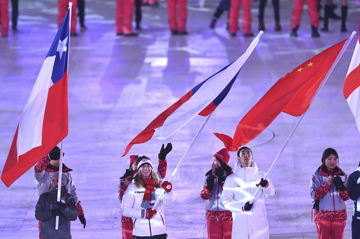 Ester Ledecká přichází s českou vlajkou na stadion při závěrečném ceremoniálu olympiády
