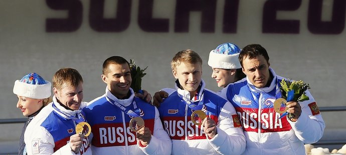 Ruský pilot Alexandr Zubkov (první zleva) se svými medailovými kolegy bobisty 