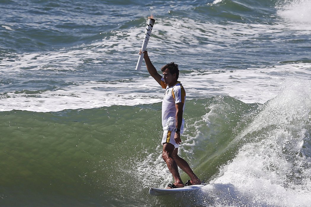 Brazilský surfař Carlos Burle v Ipojuce s olympijským ohněm