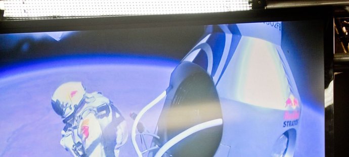 Záběry na televizní obrazovky z řídícího střediska, na kterých Felix Baumgartner právě vyskakuje z plošiny svého balonu a vrhá se do hloubky 39 kilometrů