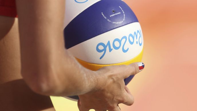 Markéta Sluková, česká plážová volejbalistka, drží míč během utkání olympijského turnaje.