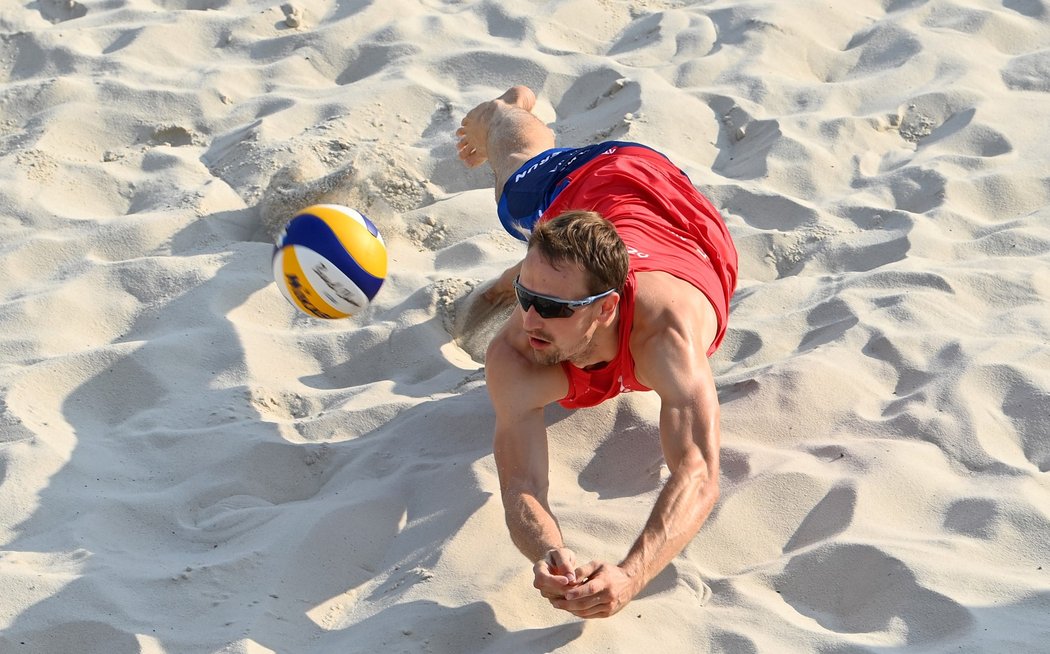 Ondřej Perušič zasahuje v pádu míč ve čtvrtfinále Prague Beach Open proti Nizozemcům