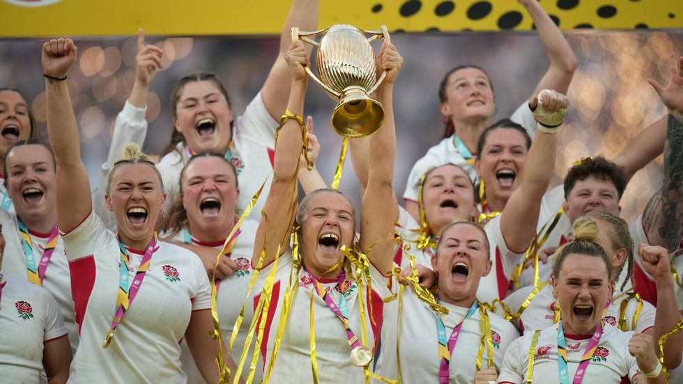 Angličanka Zoe Aldcroft drží trofej a oslavuje se svými spoluhráčkami vítězství ve finále MS v ragby