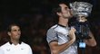 Poražený Rafael Nadal sleduje Rogera Federera s pohárem pro vítěze Australian Open