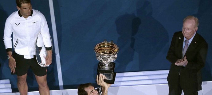 Roger Federer zvedá trofej pro vítěze Austalian Open, sleduje ho poražený finalista Rafael Nadal