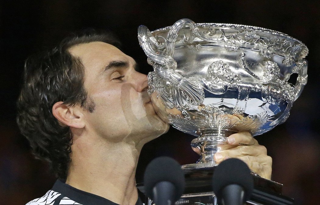 Roger Federer vášnivě líbá svůj pohár pro vítěze Australian Open. V Melbourne triumfoval už popáté v kariéře.