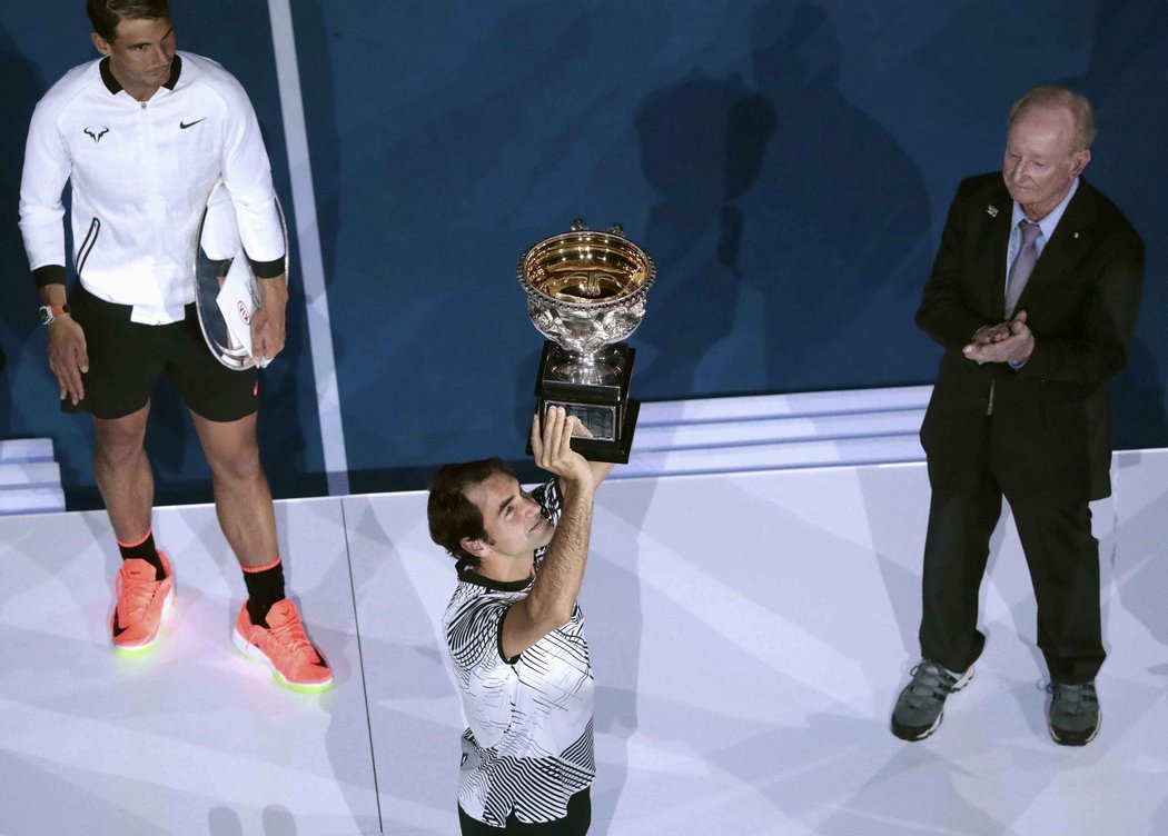 Roger Federer zvedá trofej pro vítěze Austalian Open, sleduje ho poražený finalista Rafael Nadal