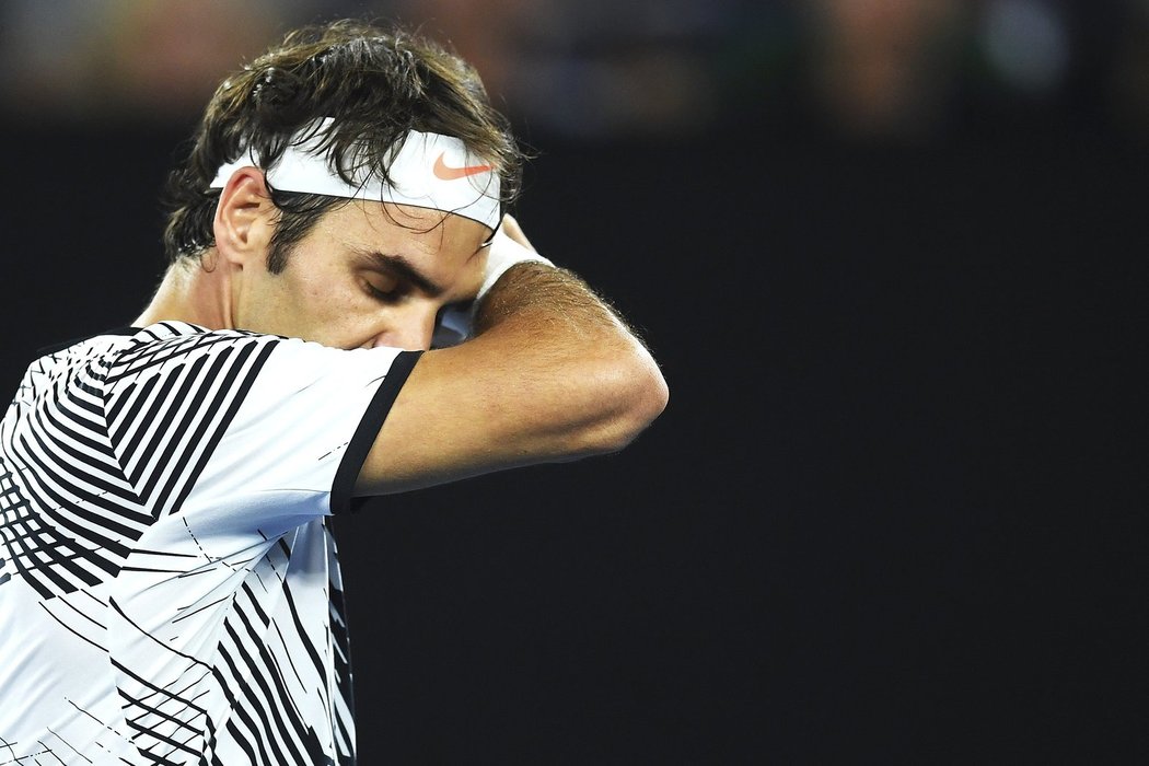 Roger Federer stírá pot z čela ve finále Australian Open proti Rafaelu Nadalovi