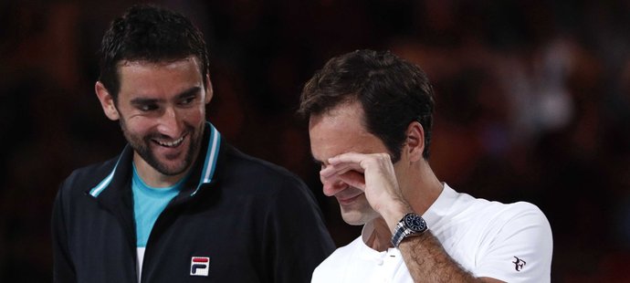 Roger Federer si utírá slzy poté, co převzal pohár pro vítěze Australian Open. Poražený Marin Čilič se ho snaží rozptýlit...