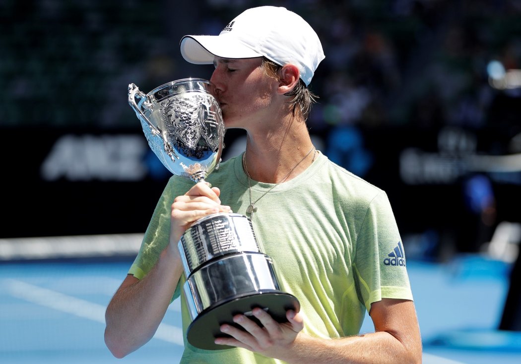 Sebastian Korda líbá pohár pro vítěze juniorky na Australian Open