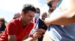 Novak Djokovič se podepisuje těhotné fanynce na břicho poté, co na pláži pózoval s pohárem pro vítěze Australian Open