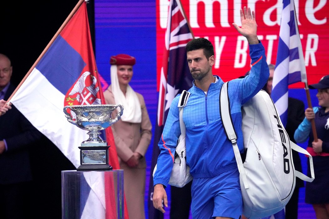 Novak Djokovič prochází před zápasem kolem trofeje