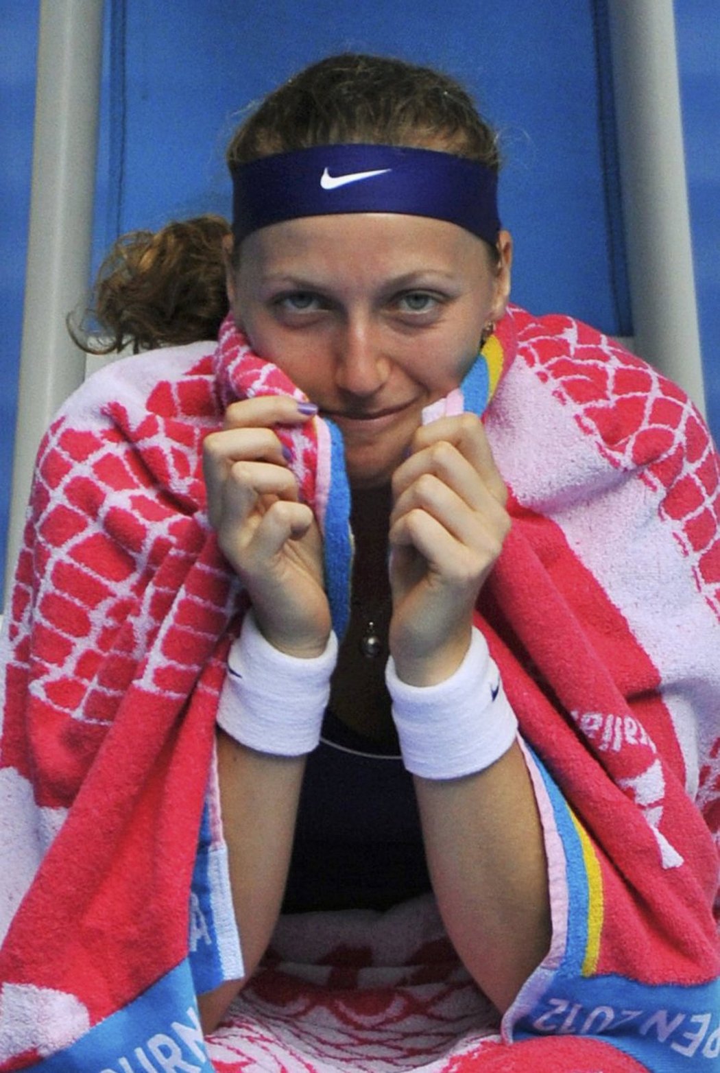 Petra Kvitová zabalená v ručníku čeká, jestli Maria Kirilenková bude moci dál pokračovat ve hře
