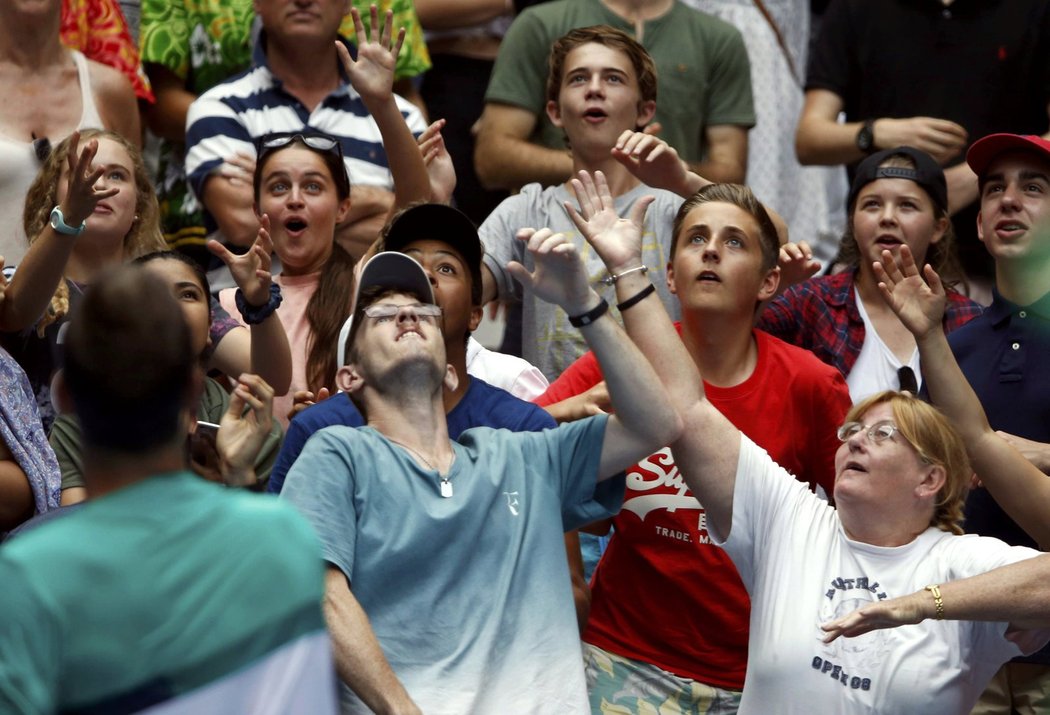 Fanoušci chytají potítko, které jim hodil Tomáš Berdych (vlevo) po svém postupu do třetího kola Australian Open