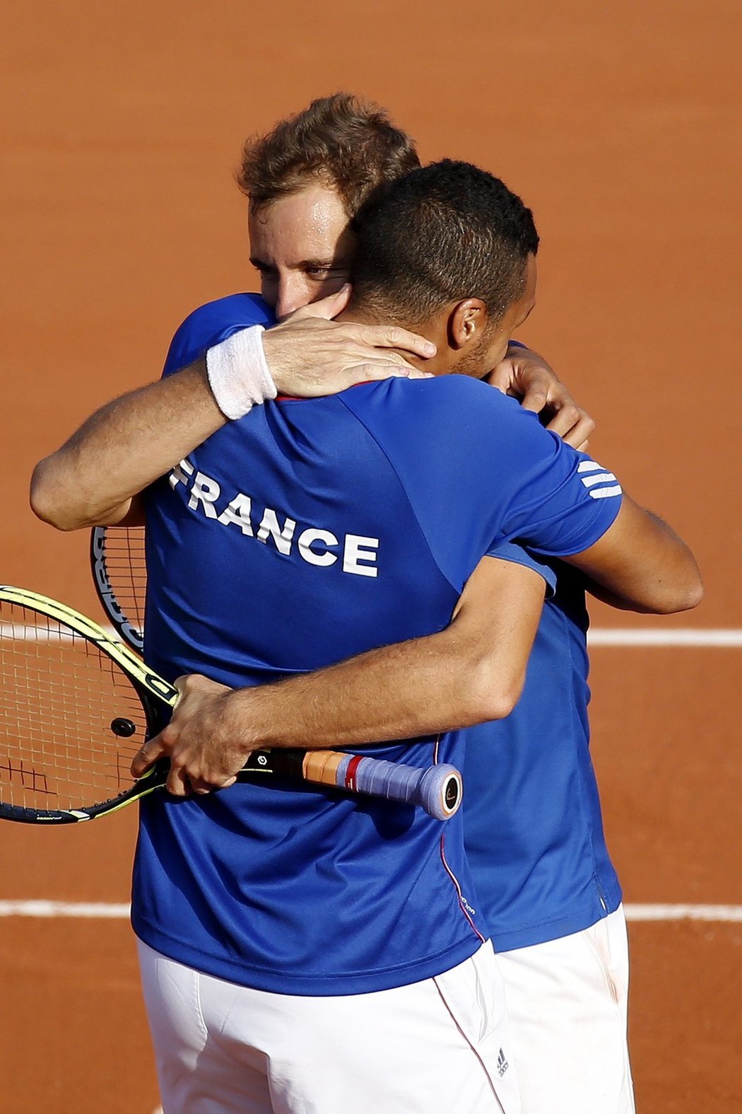 Richard Gasquet (vzadu) objímá Jo-Wilfrieda Tsongu po výhře ve čtyřhře a postupu do finále Davis Cupu