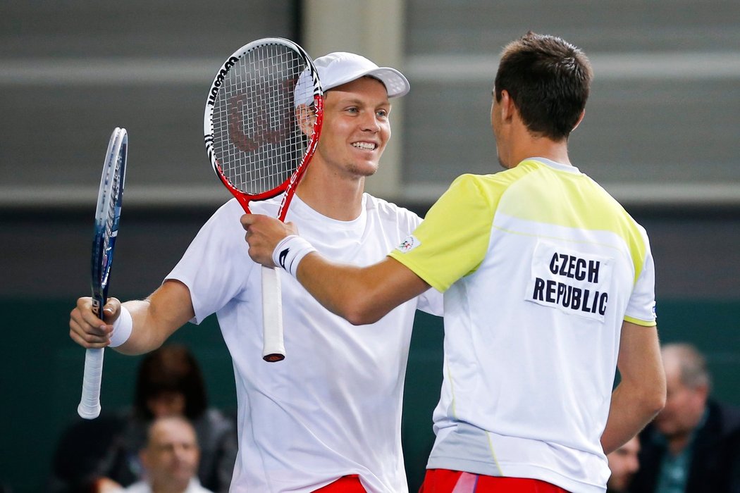 Tomáš Berdych (vlevo) jde obejmout Lukáše Rosola po nejdelší bitvě v dějinách Davisova poháru. Český pár zdolal po sedmi hodinách Wawrinku s Chiudinellim