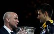 Bývalá tenisová hvězda Andre Agassi předává Djokovičovi pohár pro vítěze Australia Open