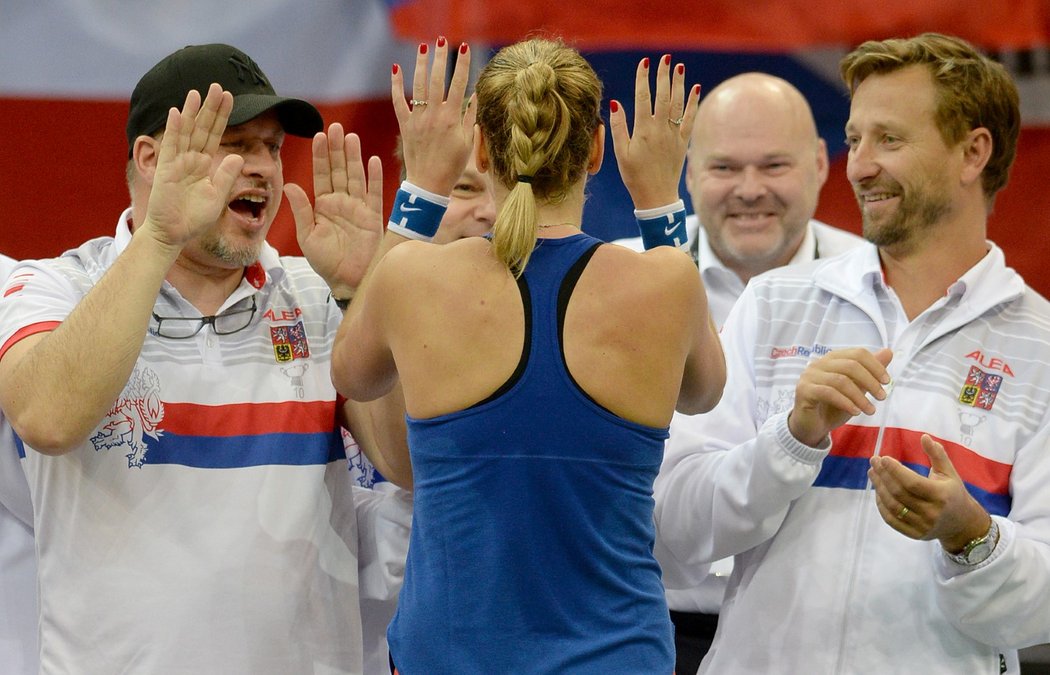 Petra Kvitová se raduje  s členy českého fedcupového týmu po výhře nad Švýcarkou Bencicovou