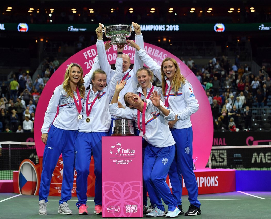 Lucie Šafářová, Barbora Krejčíková, Petr Pála, Kateřina Siniaková, Petra Kvitová a dole Barbora Strýcová pózují s Fed Cupem. Pošesté za posledních osm let...