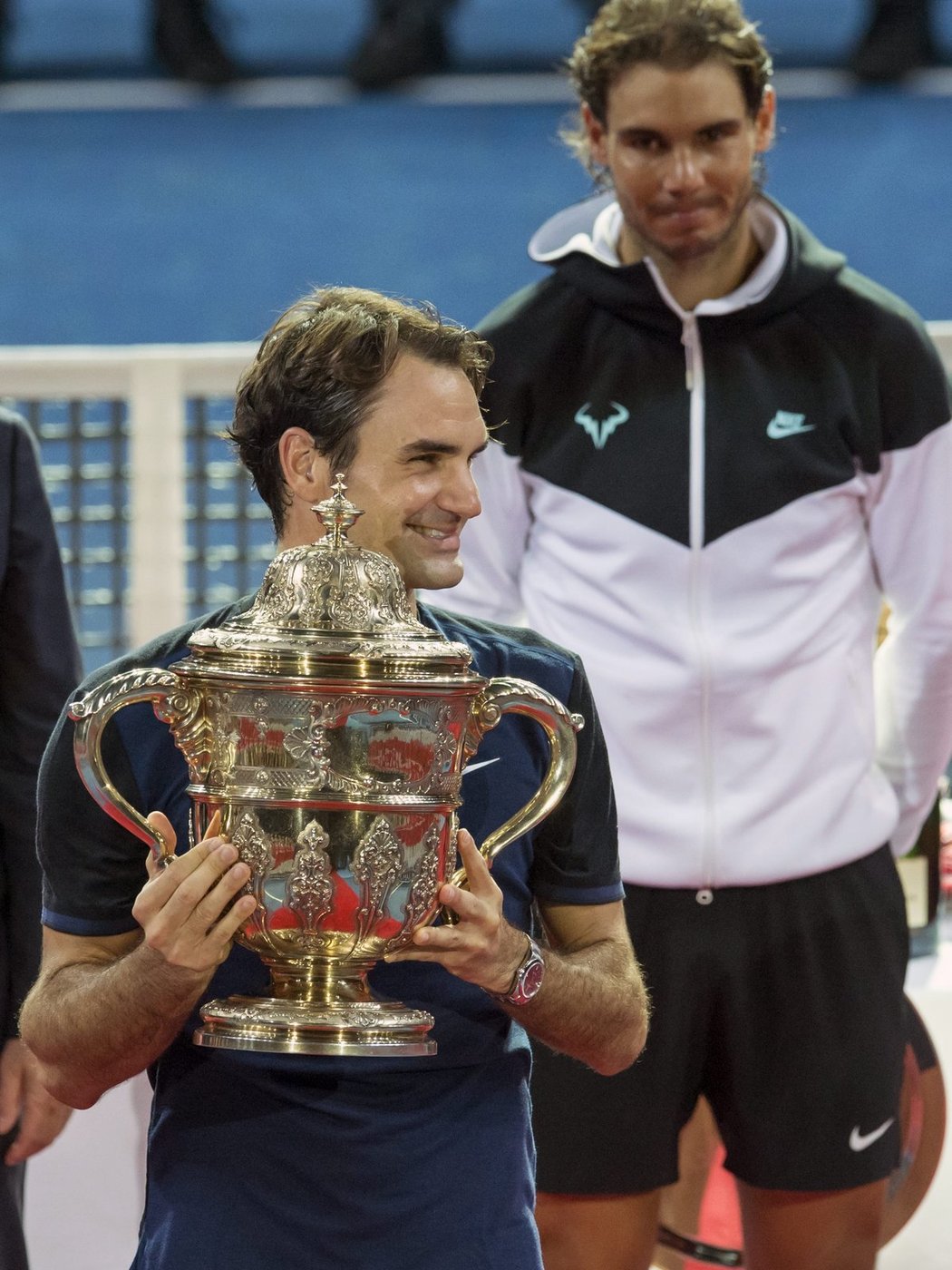 Roger Federer s vítěznou trofejí, v pozadí poražený finalista Rafael Nadal